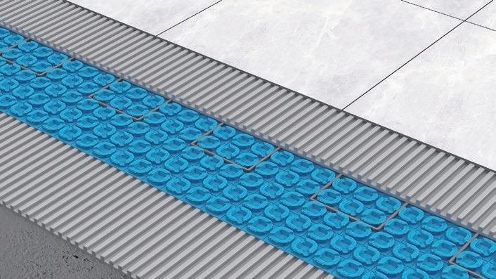Detail of a blue uncoupling mat assembly under a marble-look tile floor showing the dovetailed profile
